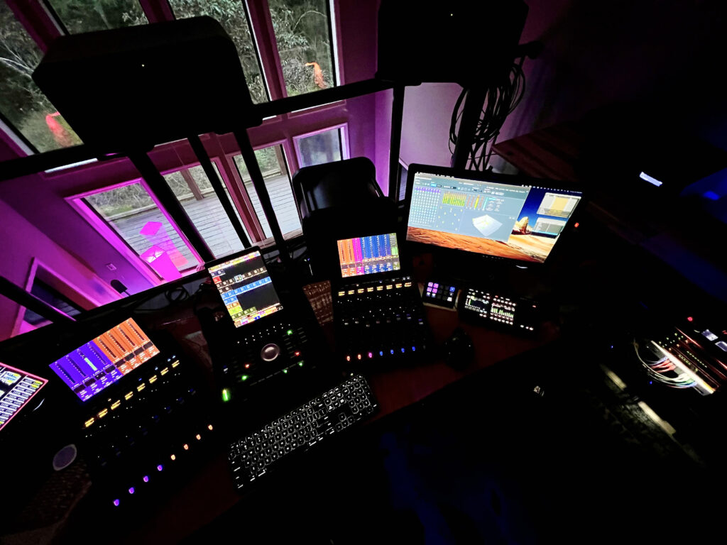 Dolby Atmos control desk with Avid control surfaces and monitors glowing at night at Sonic Forest Studios