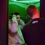 DJ Boitano putting on headphones in the ADR vocal booth at Sonic Forest Studios, Victoria BC