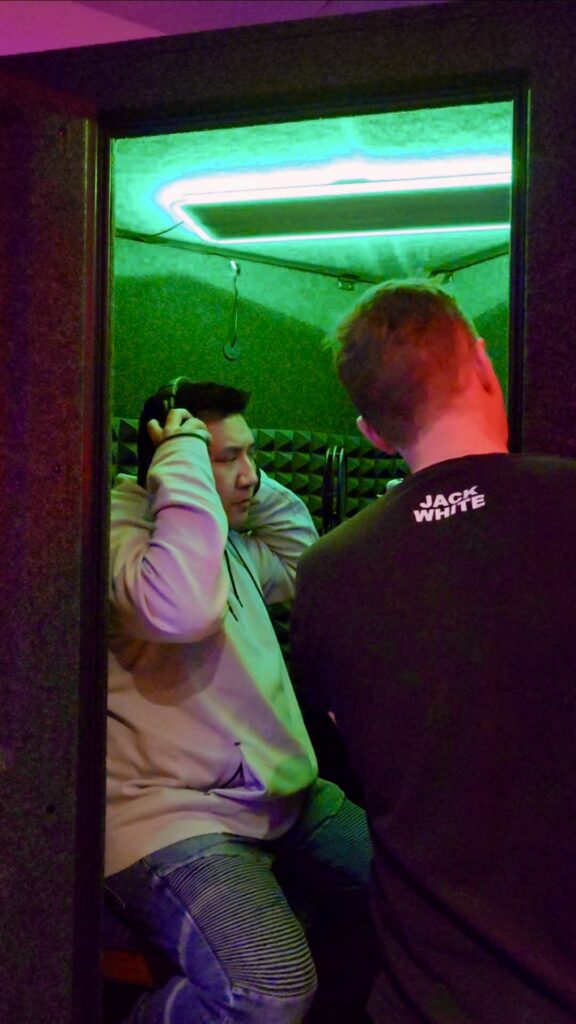 DJ Boitano putting on headphones in the ADR vocal booth at Sonic Forest Studios, Victoria BC